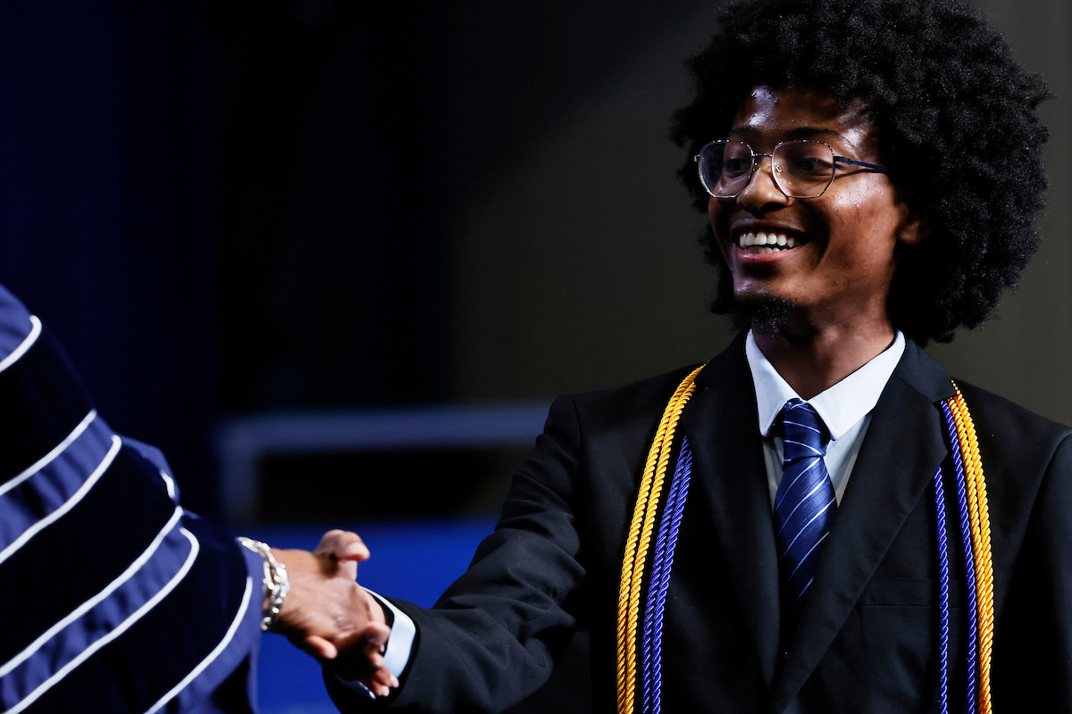 male student shakes hands with jsu leader