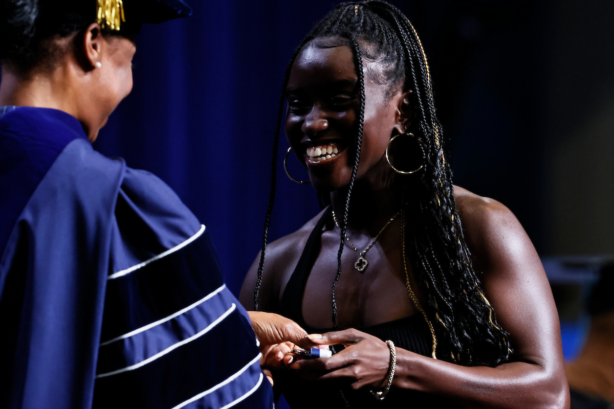 female student receives medal from President Gregory