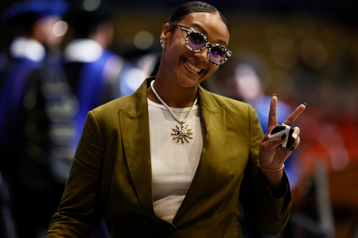 female student smiling and holding peace sign