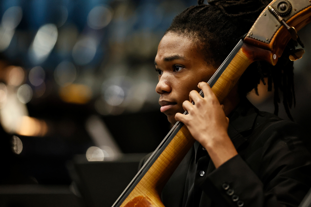 male student plays musical instrument