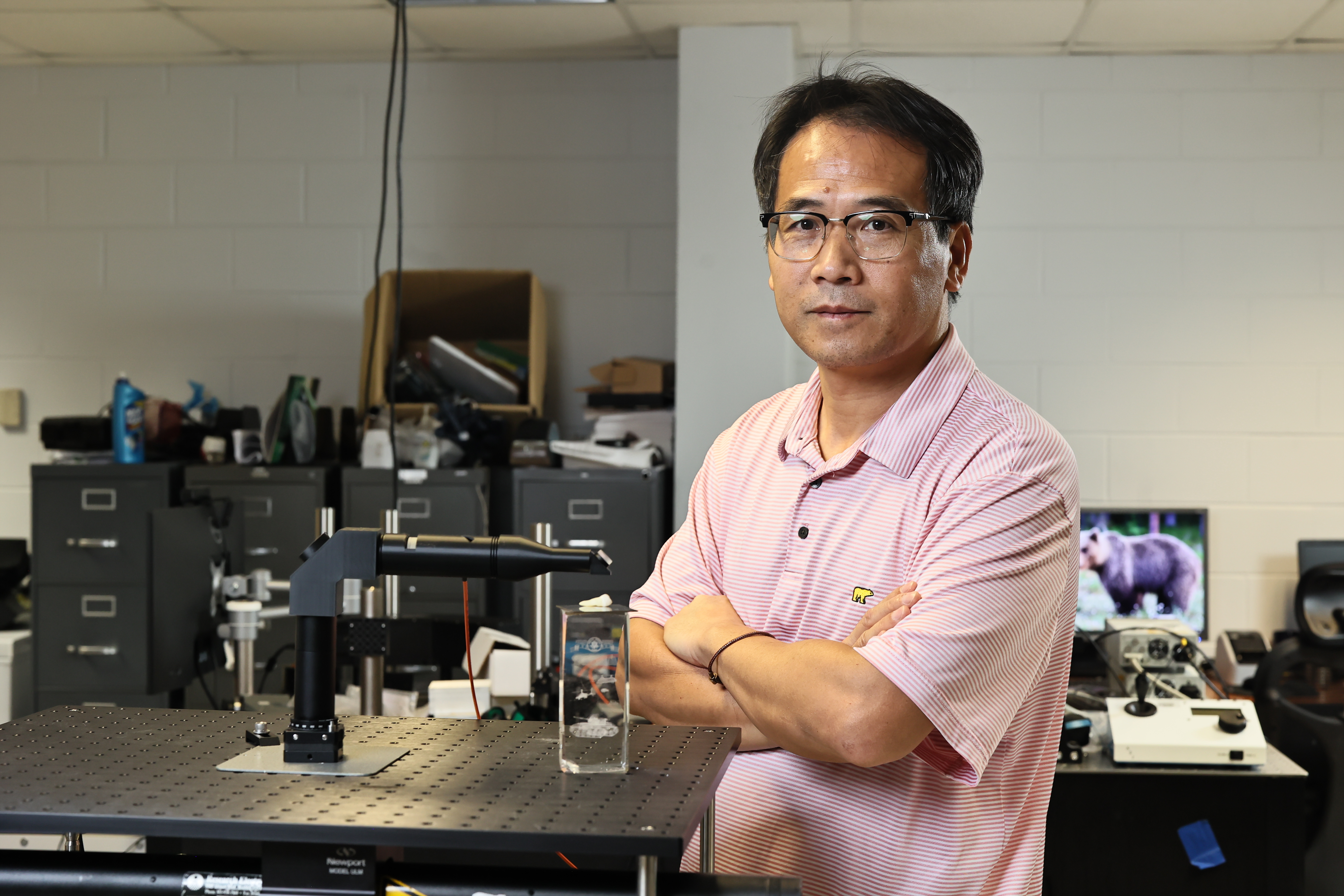 JSU professor Shan Yang, Ph.D., stands next to his patented a tool designed to detect early-stage tooth decay.