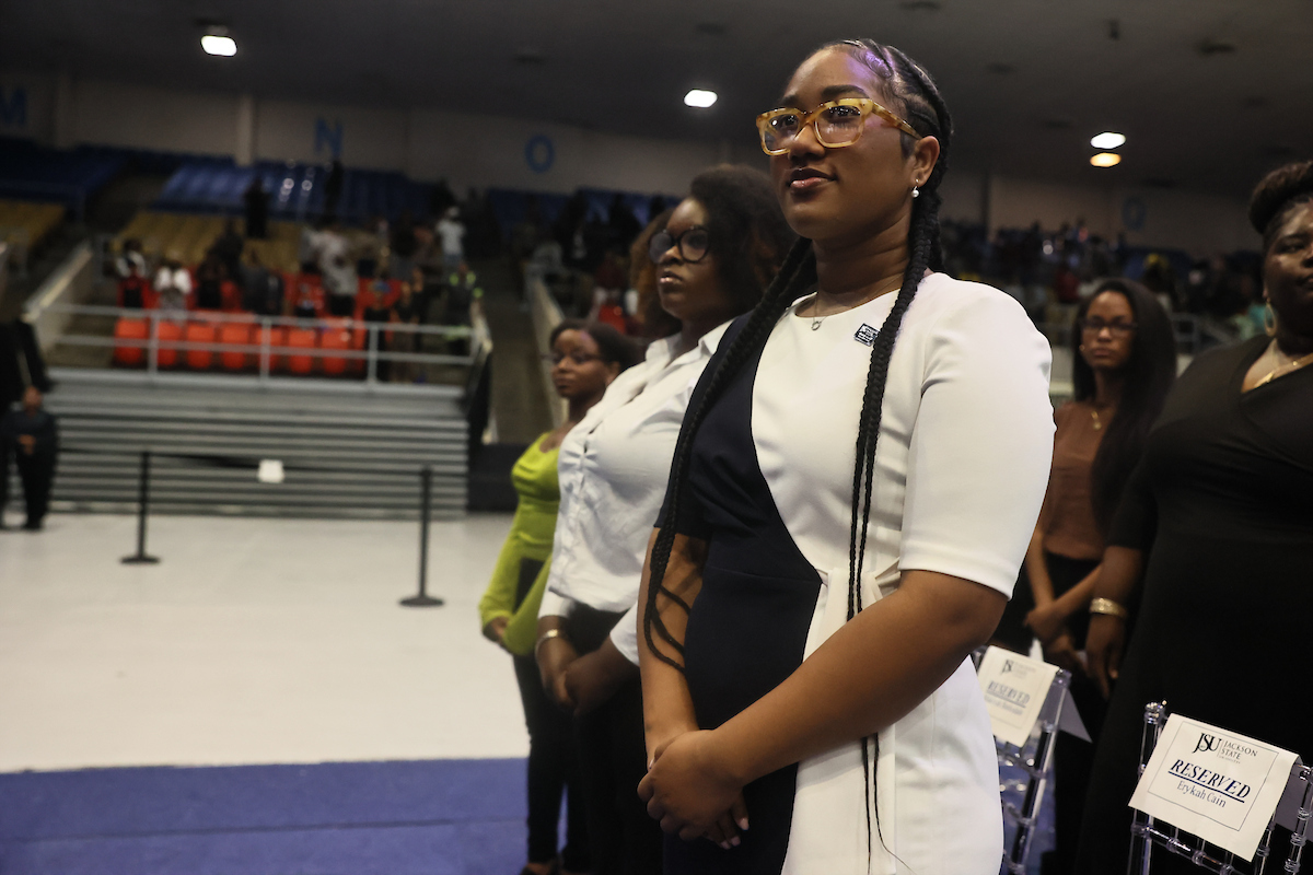 students stand at ceremony