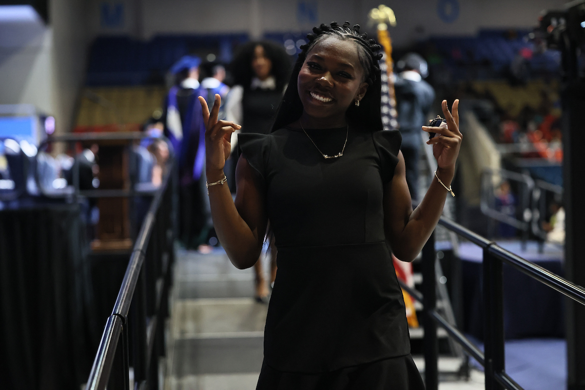 female student smiling holding peace signs