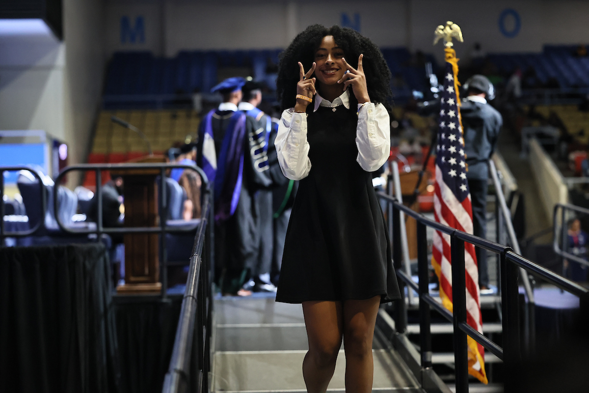 female student smiling holding peace signs