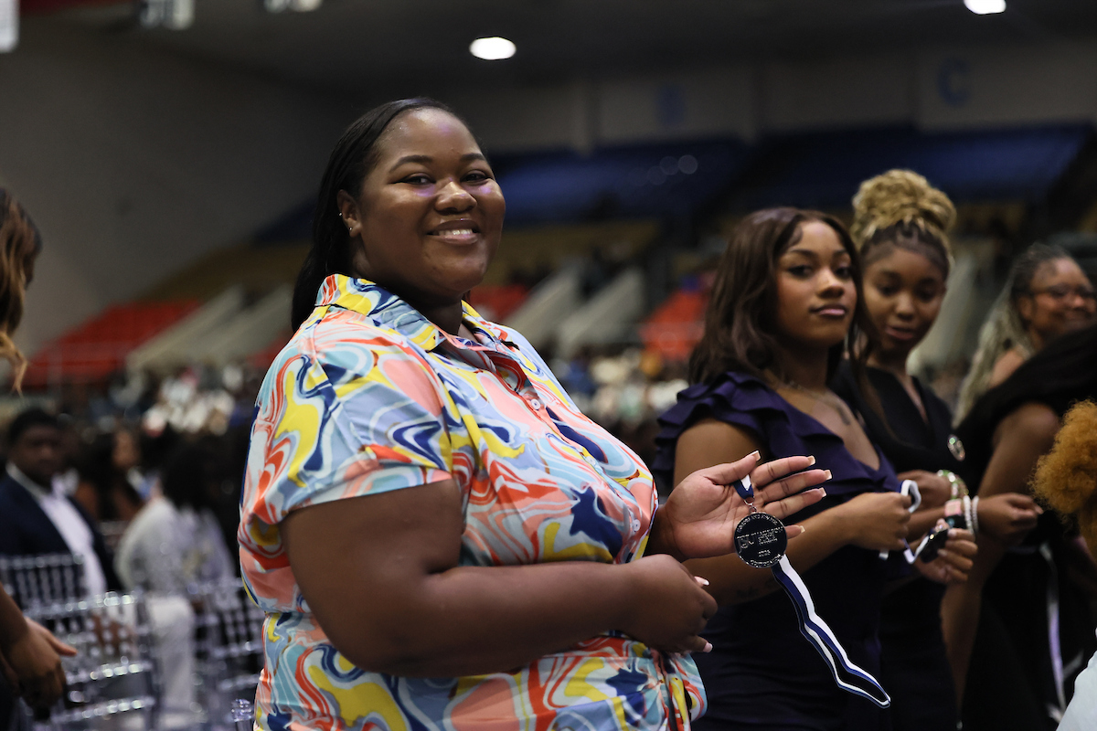 female student smiles with medal