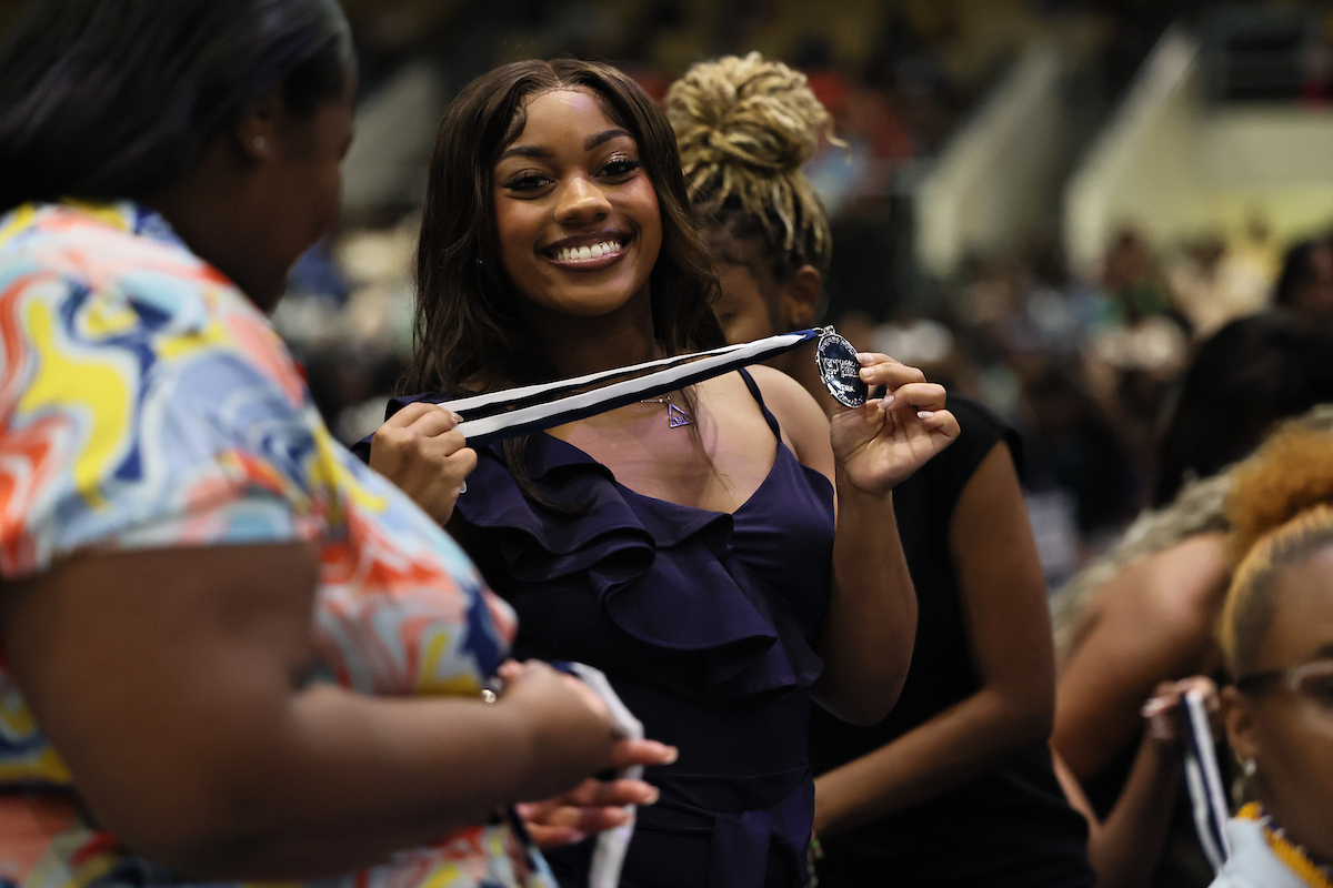 female student smiling with medal