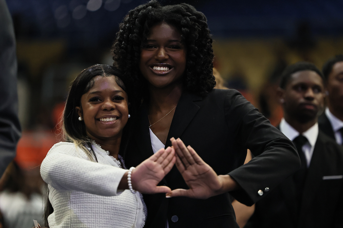 female students holding up Delta sign