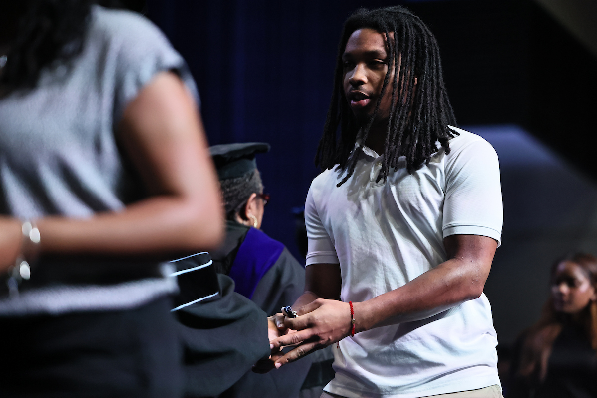 Male student shakes hand of JSU leaders