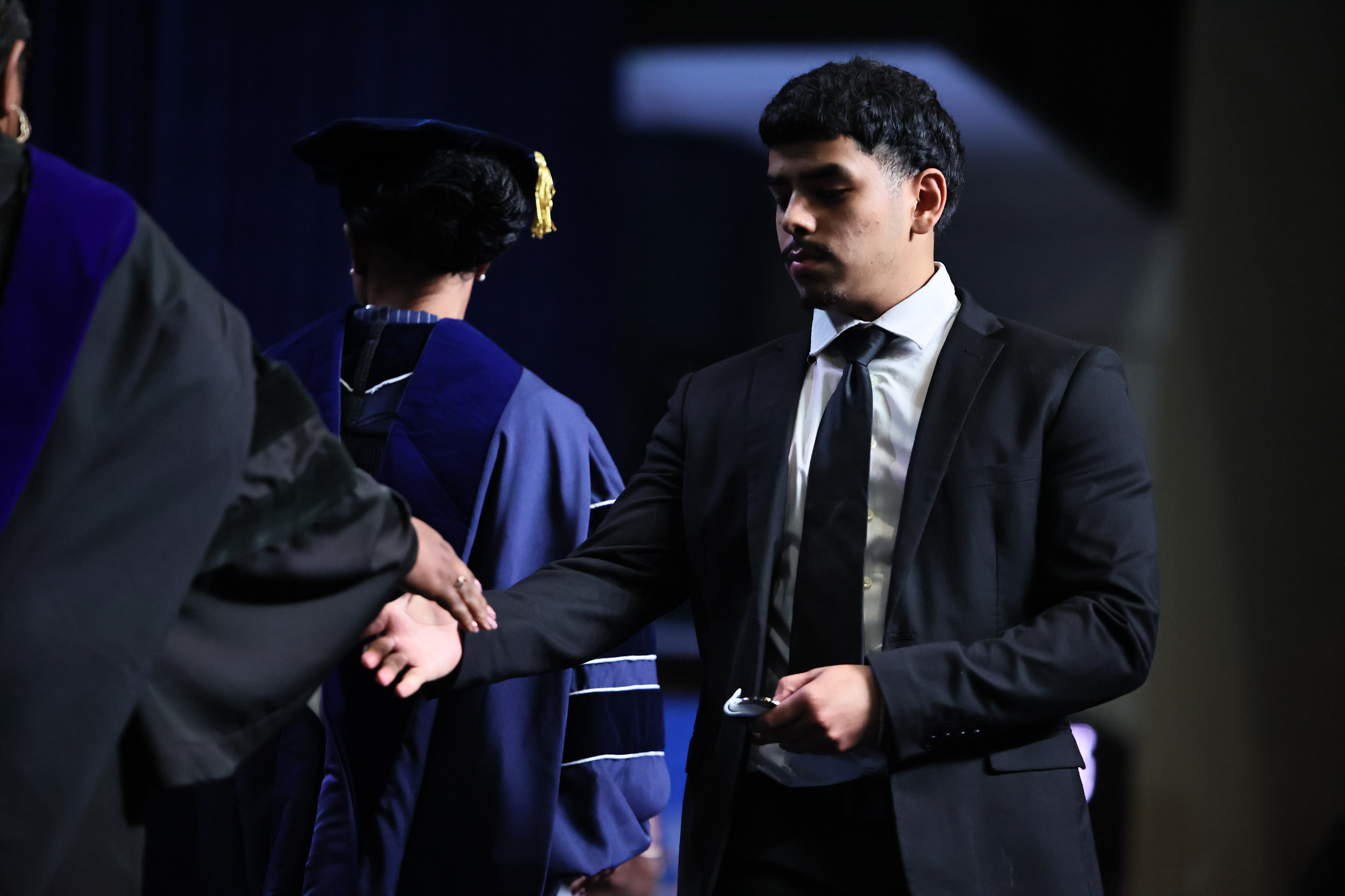 student shakes hands with faculty member