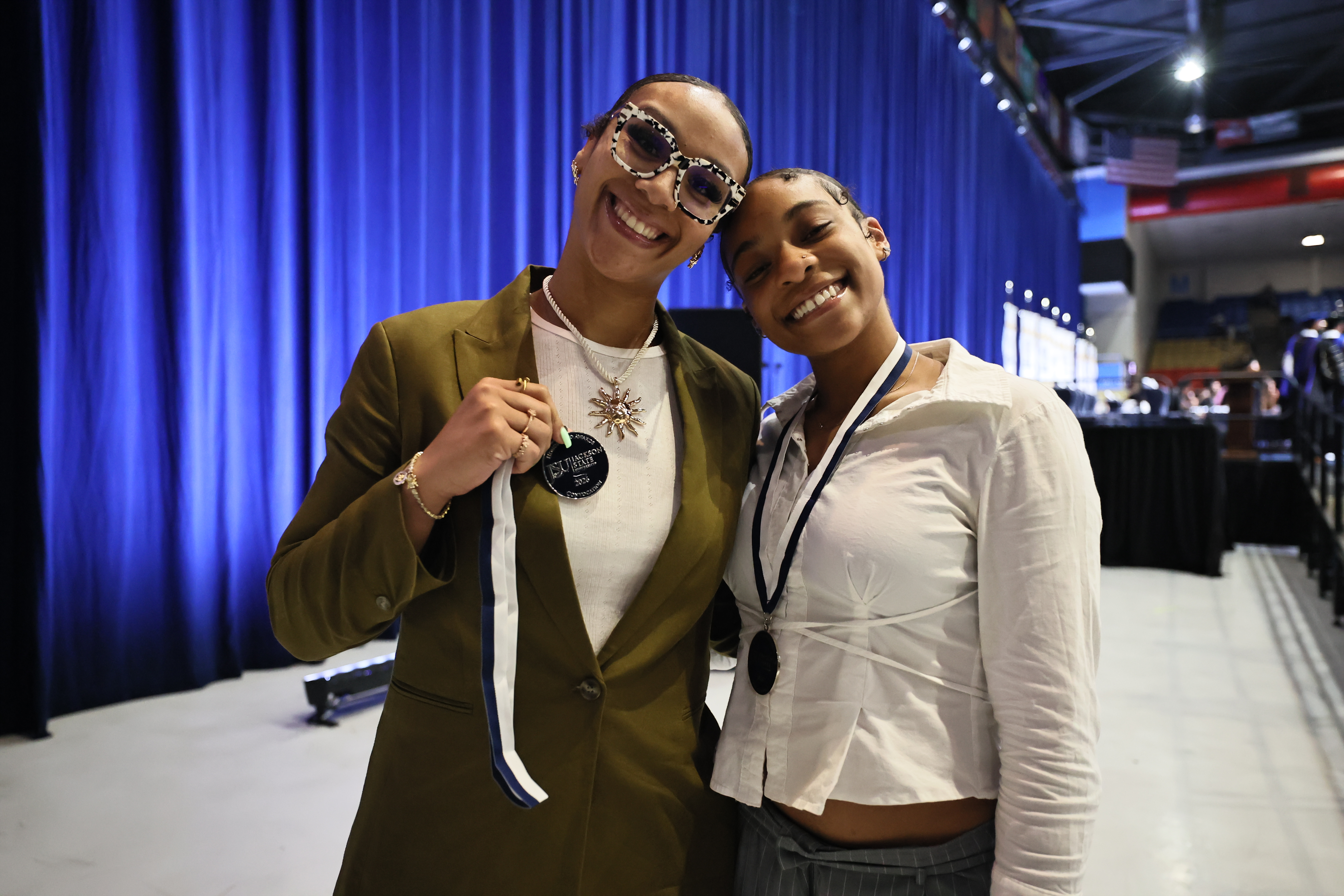two female students smile with medals